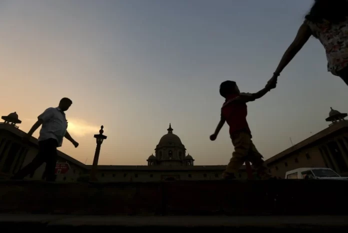 Commuters walk past the building of India's Ministry of Finance during dusk in New Delhi, India, May 18, 2015. REUTERS/Adnan Abidi
