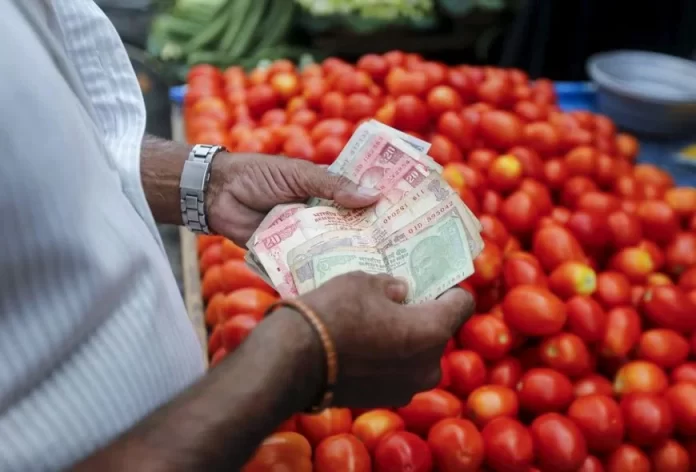 A customer counts money before paying a vegetable vendor at a market in Mumbai, India, June 4, 2015. REUTERS/Shailesh Andrade/Files